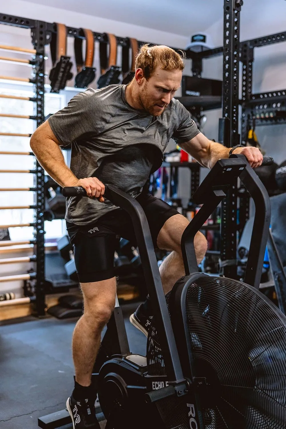 Athlete riding an air bike in a gym